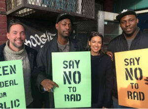 Stan Morse ’85 holds a Say No To Rad sign, alongside US Representative for NY-14, Alexandria Ocasio-Cortez in the center of a group of four.