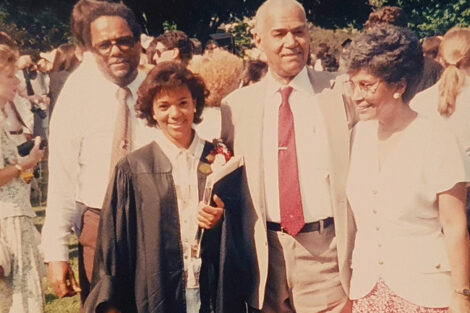 Deneen Blow with three family members at Commencement. Blow is wearing a black graduation robe.