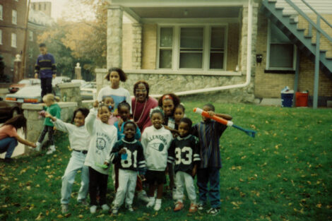 Mbadugh stands with a group of children.