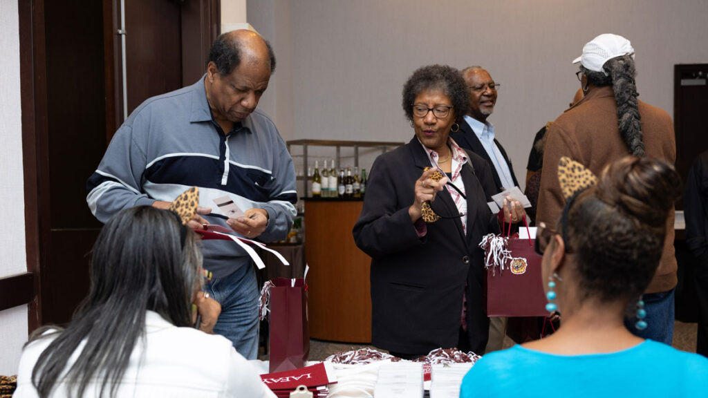 A man and a woman are at a registration table. 