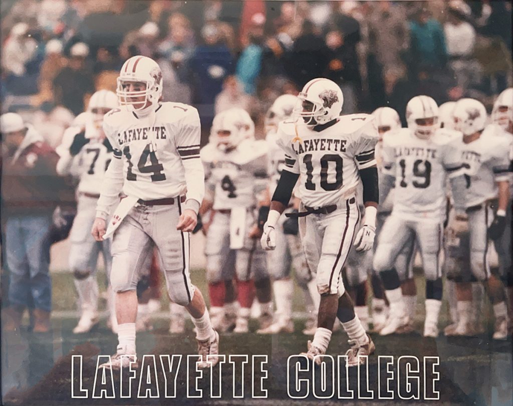 Lafayette football team in white uniforms walking out onto the field
